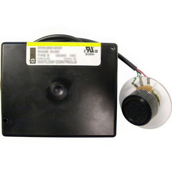 The back of a black electronic device with a round plastic cap and a wire.