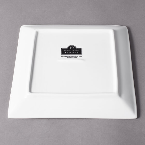 A white square porcelain plate with a black logo.