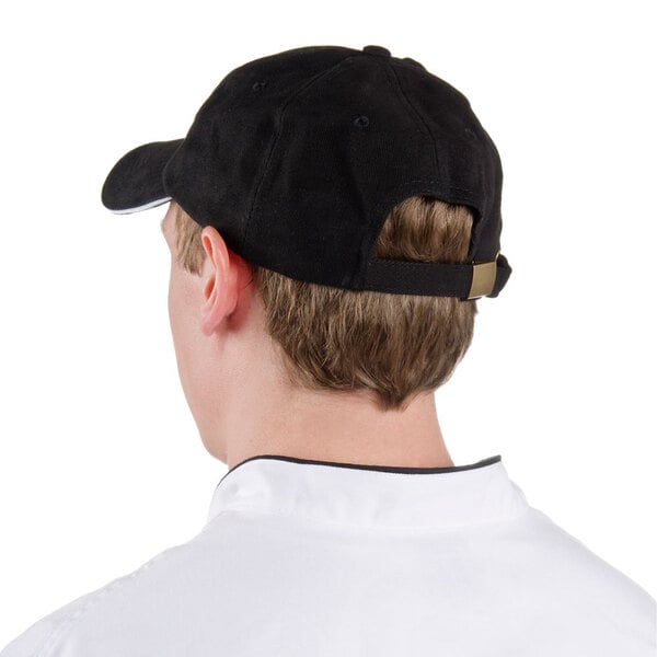 A man wearing a black Chef Revival baseball cap with white logo.
