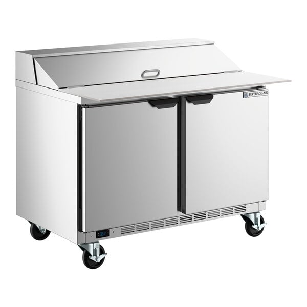 A stainless steel two-door refrigerated sandwich prep table with a raised cutting top and a 17-inch deep cutting board on wheels.