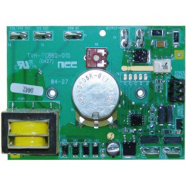 A close-up of a green circuit board with a yellow button and a round metal object.