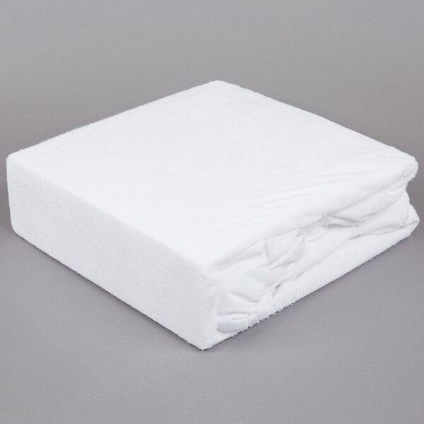 A white mattress cover on a gray surface.