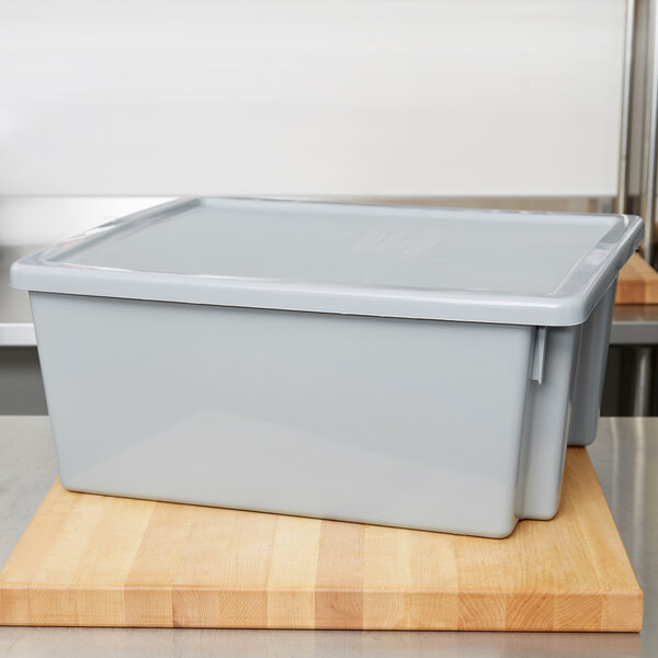 A gray Rubbermaid tote box lid on a wooden surface.