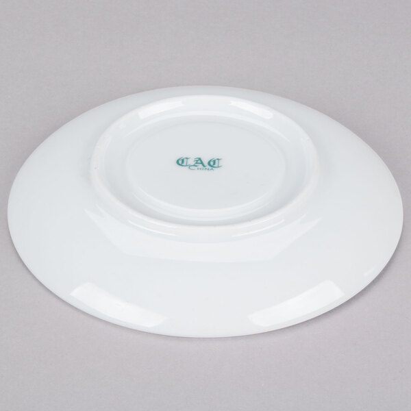 A white CAC saucer with green writing.