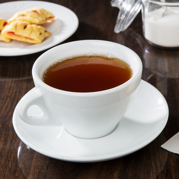 A CAC white cup of tea on a saucer.