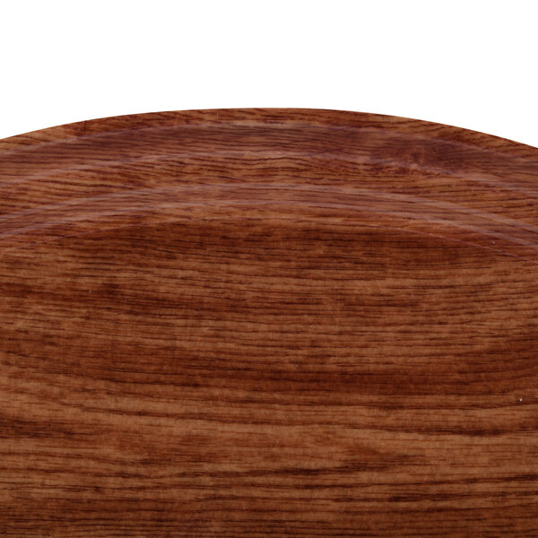 A close-up of a wooden surface with the Cambro Country Oak fiberglass tray design.