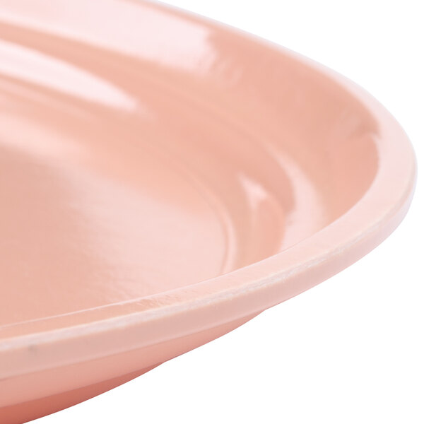 A close up of a dark peach Cambro oval tray with a rim.