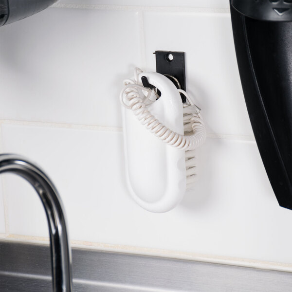 A white Carlisle Sparta hand and nail brush kit on a white wall.