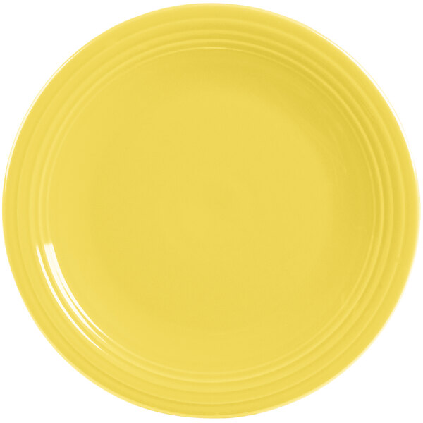 A yellow Fiesta® round chop plate with a white rim.