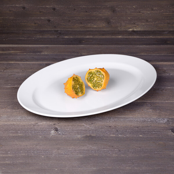 An Elite Global Solutions white oval melamine platter with cut up oranges on it.
