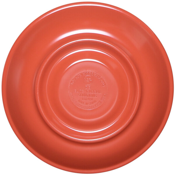 A close-up of a coral melamine coffee saucer with a circle in the middle.