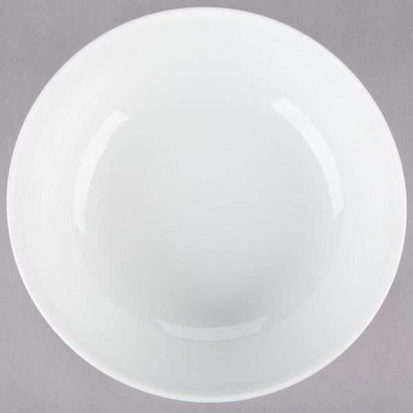 A white bowl with a curved edge on a gray surface.