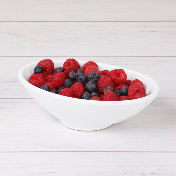 A white Elite Global Solutions melamine bowl filled with raspberries and blueberries.