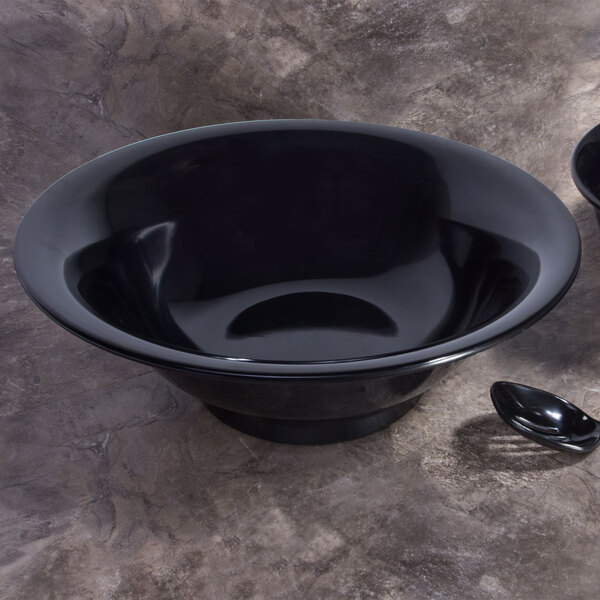 An Elite Global Solutions black flared bowl on a marbled surface with a spoon inside.