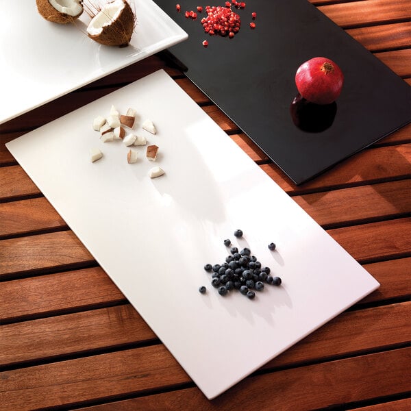 An Elite Global Solutions black melamine flat tray with fruit on it.