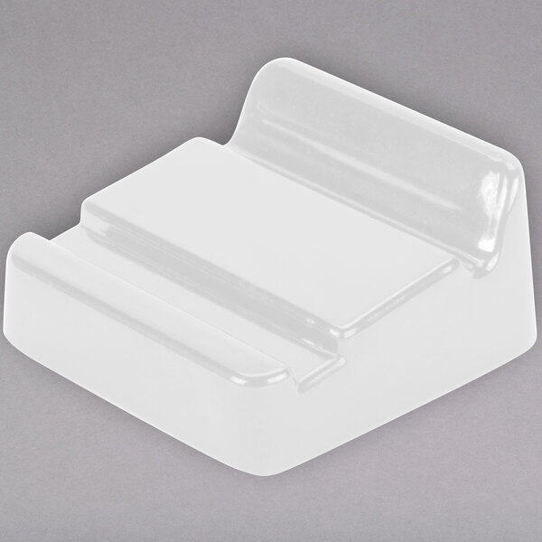 A white Elite Global Solutions wedge for trays with curved edges.