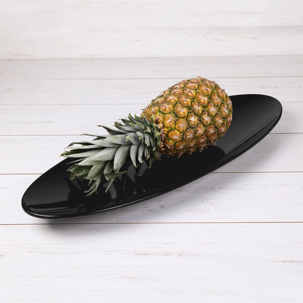 An Elite Global Solutions Moderne black melamine oblong platter with a pineapple on it.