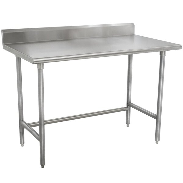 A stainless steel Advance Tabco work table with a backsplash on adjustable legs.