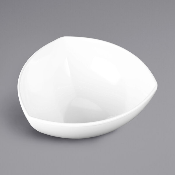 A white Elite Global Solutions triangular melamine bowl on a gray surface.