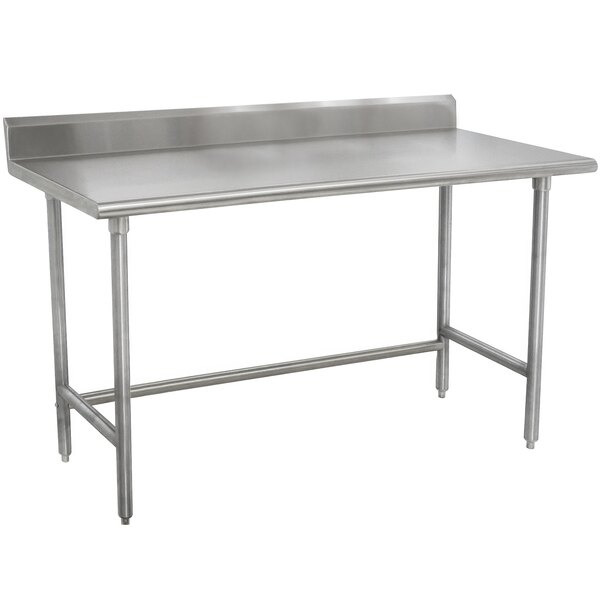A stainless steel Advance Tabco work table with a backsplash and open base.