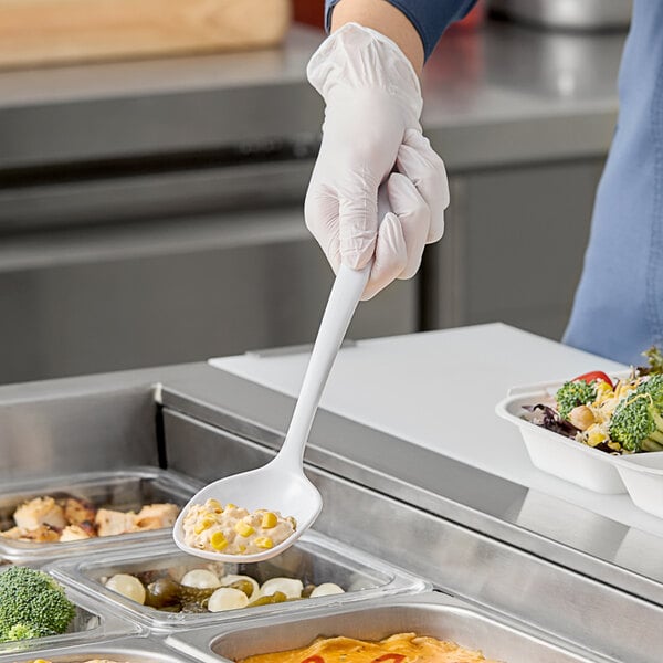 A person in gloves holding a white Elite Global Solutions spoon over food.