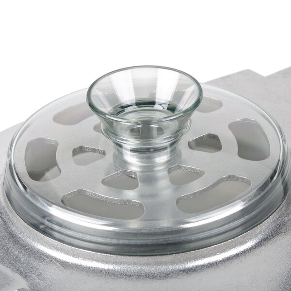 A clear bowl with a lid on top of a metal container.