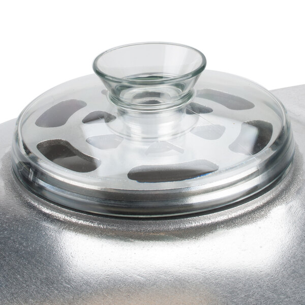 A clear glass lid on a silver food processor bowl.