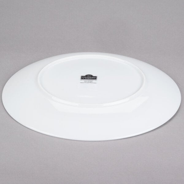 A white porcelain charger plate with a black rim.