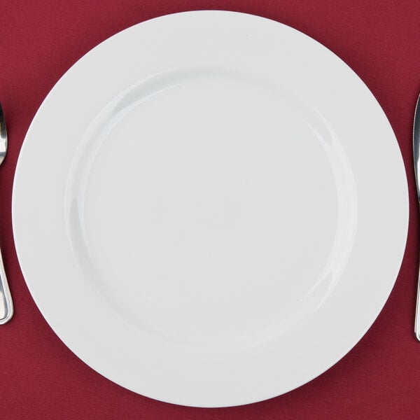 A white 10 Strawberry Street porcelain charger plate with a fork and knife
