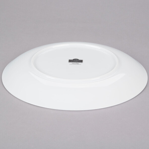 A white 10 Strawberry Street Royal Coupe porcelain plate on a gray surface.
