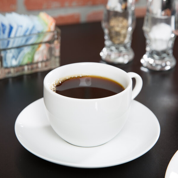 A 10 Strawberry Street white porcelain cup of coffee on a saucer.