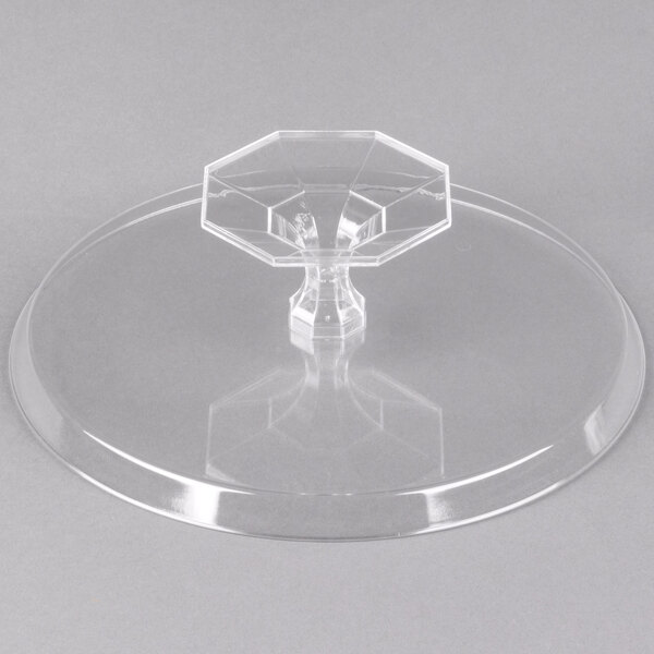 A clear plastic two-piece cake stand with a clear plastic base and a clear plastic top with a hexagon design.