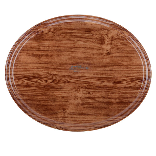 A Cambro Java Teak oval fiberglass tray with a wood grained surface.