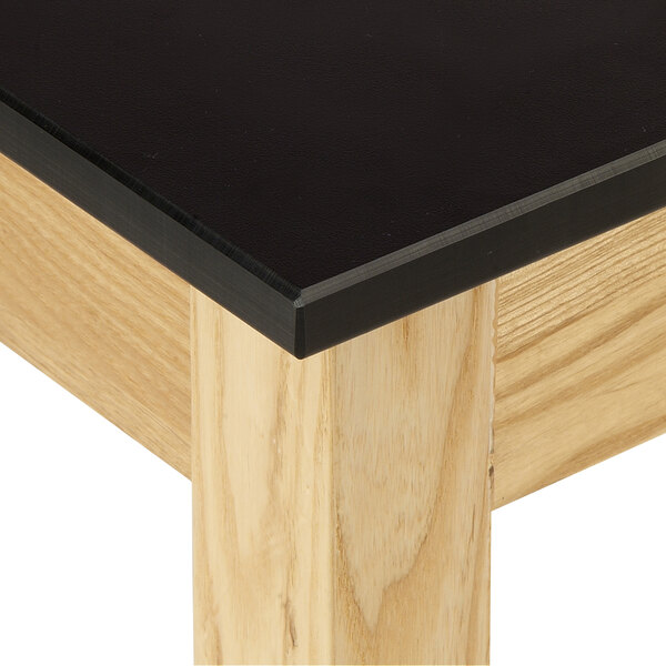 A black National Public Seating science lab table surface with wood base.
