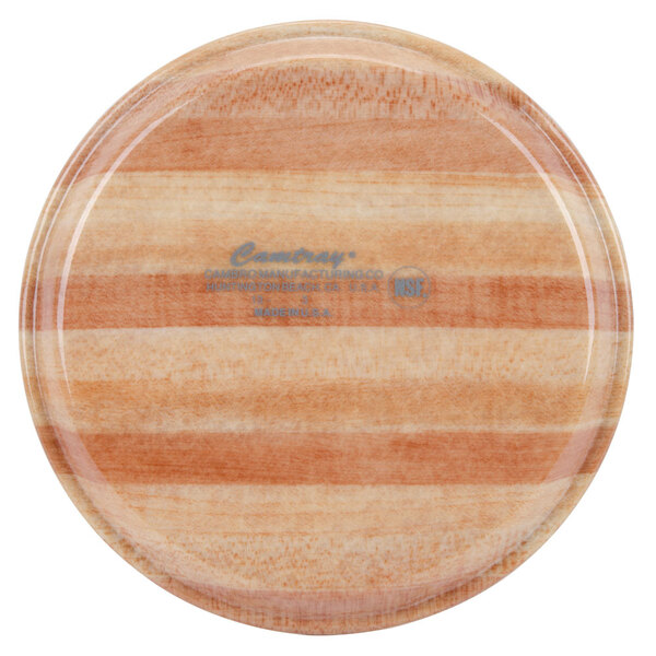 A Cambro round wooden tray with a stripe on it.