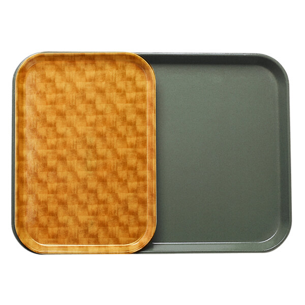 A Cambro light brown and black basketweave tray insert on a wooden tray.