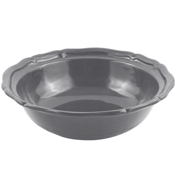 A smoke gray Bon Chef cast aluminum salad bowl with a scalloped edge and a handle.