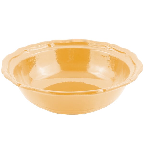 A Bon Chef Queen Anne salad bowl in ginger sandstone finish with a scalloped edge and a handle.