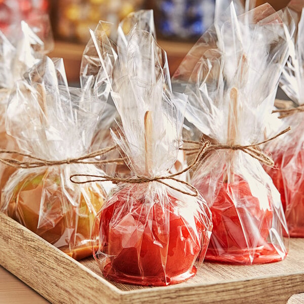 A group of red apples wrapped in clear plastic bags.