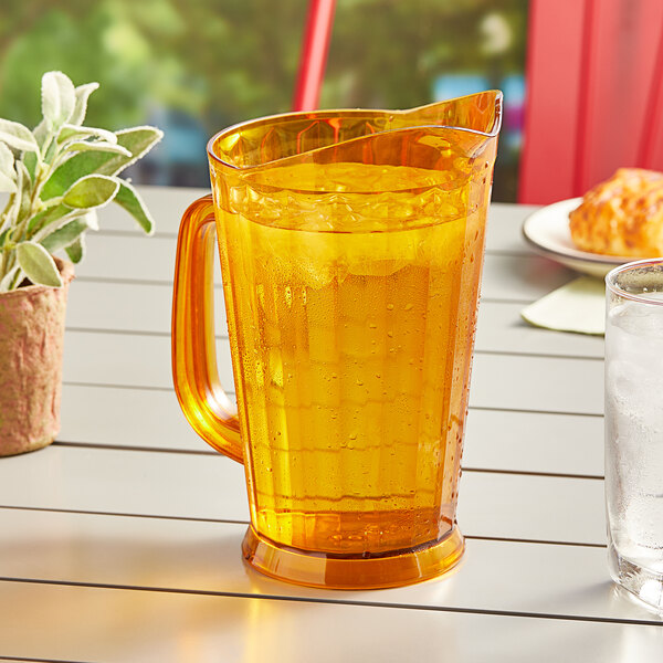 An amber GET pitcher of ice water on a table outside.