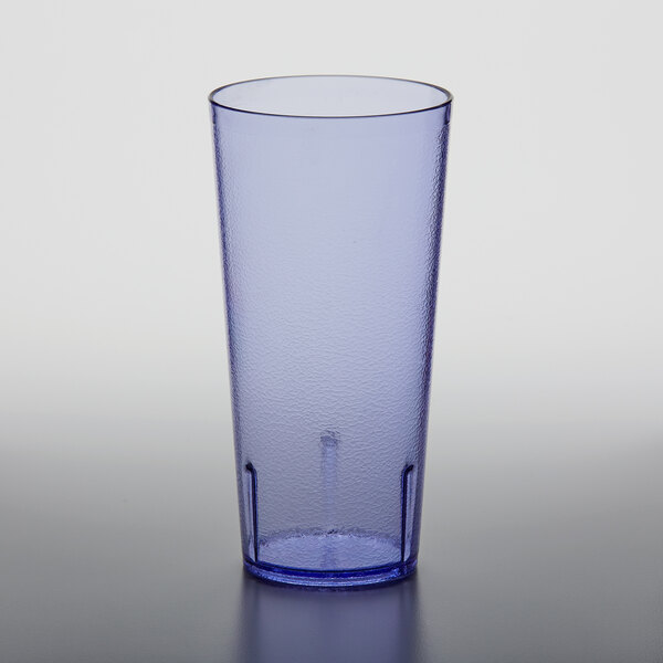 A blue plastic pebbled tumbler on a white table.