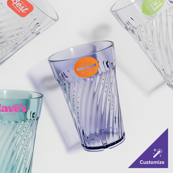 A table with empty Tahiti SAN plastic tumblers with custom designs.