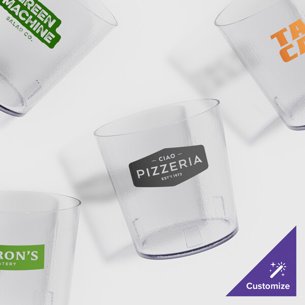 A group of clear customized short plastic tumblers with a pebbled design.