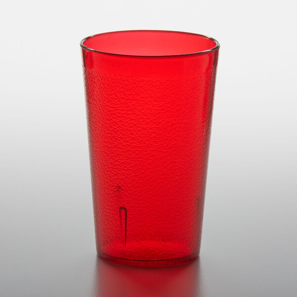 A red plastic cup on a white surface.