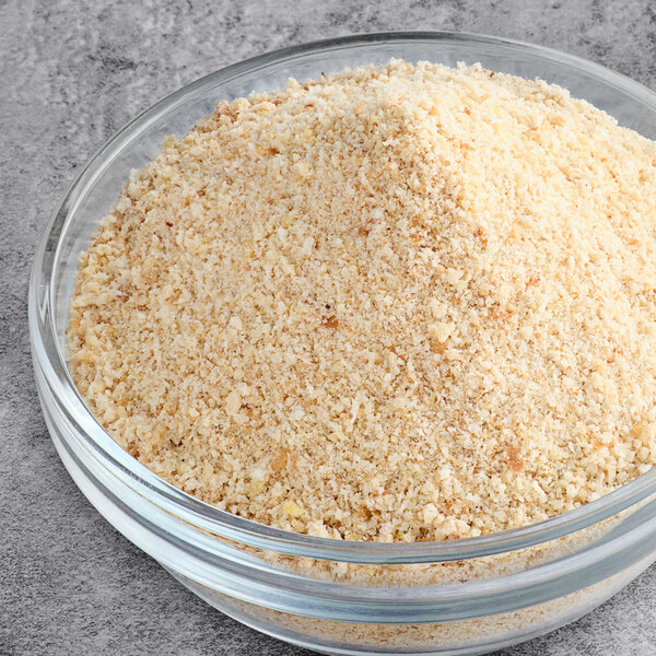 A bowl of 5 lb. plain bread crumbs on a table.