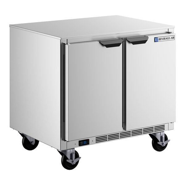 A stainless steel undercounter freezer with two doors and caster wheels.