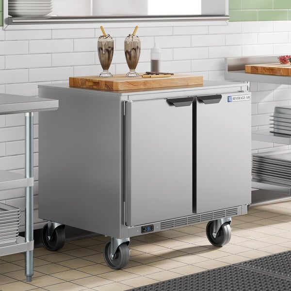 A stainless steel 36-inch undercounter freezer with double doors and caster wheels, designed for commercial kitchen use.
