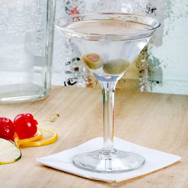 a glass stem with a white napkin and lemon slices on a wooden surface