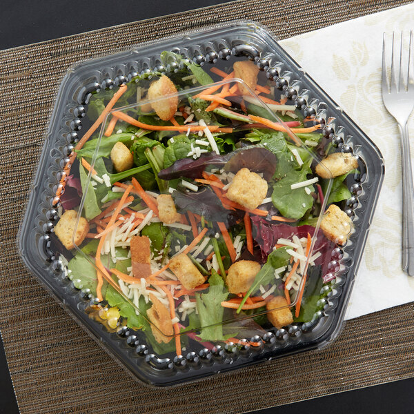 A salad in a Genpak clear plastic container with a clear hexagonal lid.