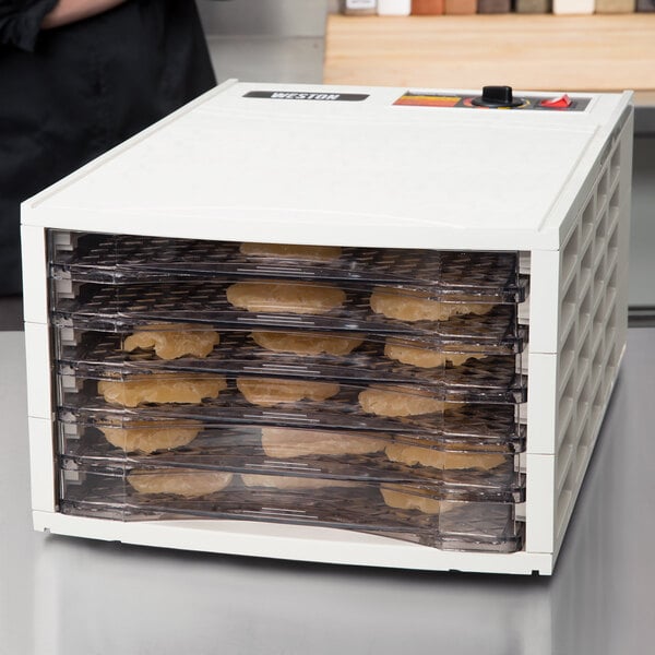 White dehydrator with food inside of it